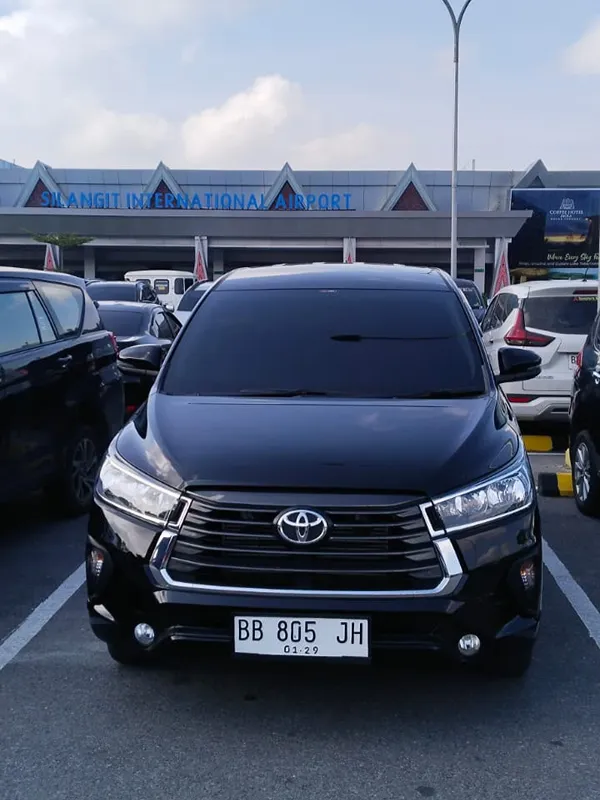 Toyota Innova hitam unit Toba Brother Rent di Bandara Silangit